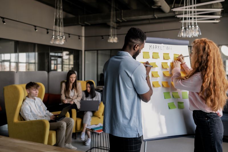 Energetic email marketing team using sticky notes on a task board