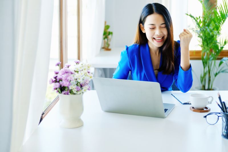 Uma mulher feliz trabalhando em sua campanha de e-mail