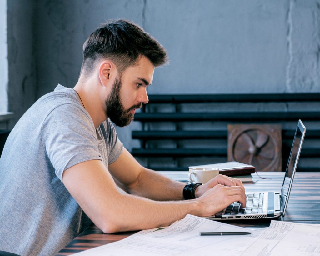 male office worker tying on laptop