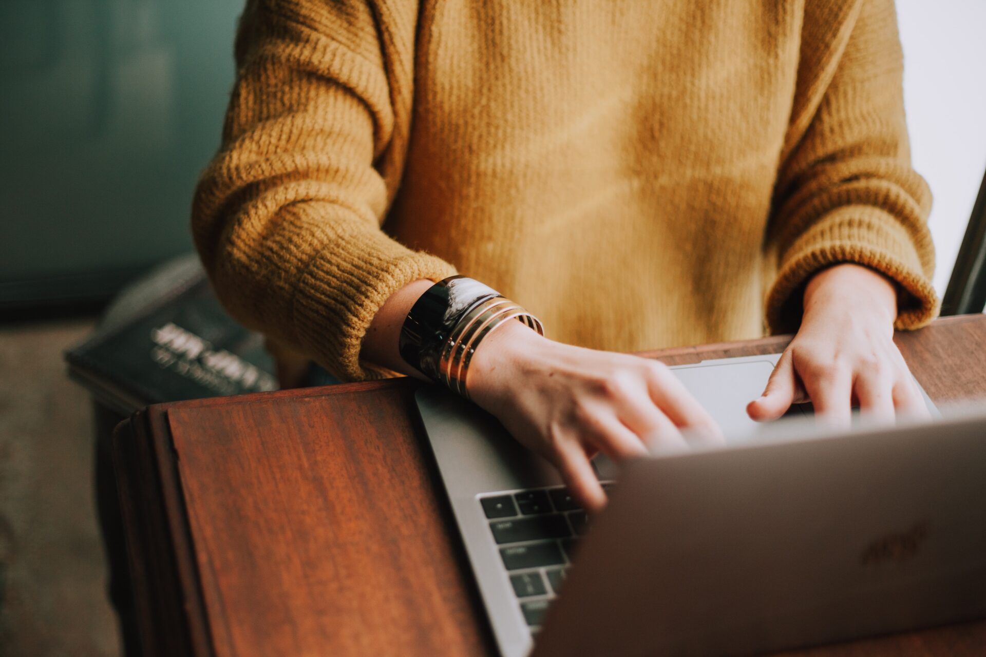 woman at desk typing on laptop