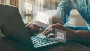 laptop showing an employees hands typing and creating emails