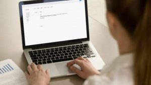email agency employee reviewing email content on laptop