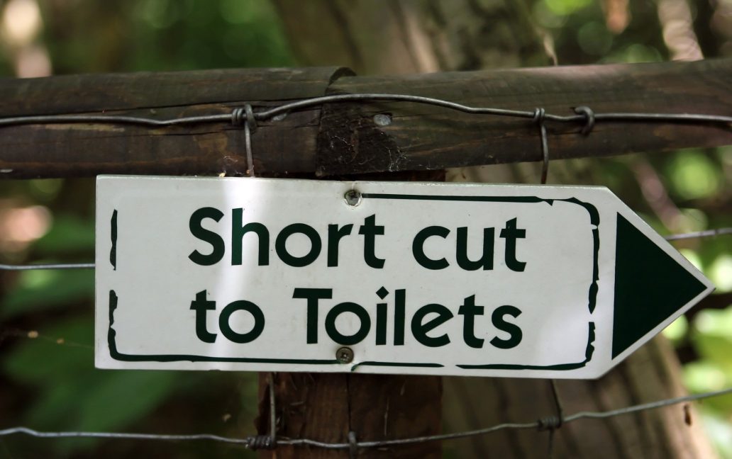 sign pointing to toilets