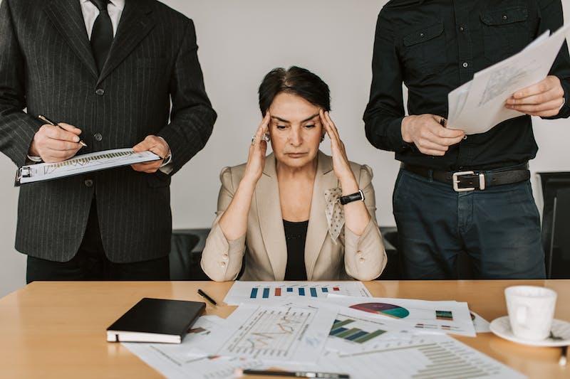 stressed woman between two men - Cold Email vs Cold Call