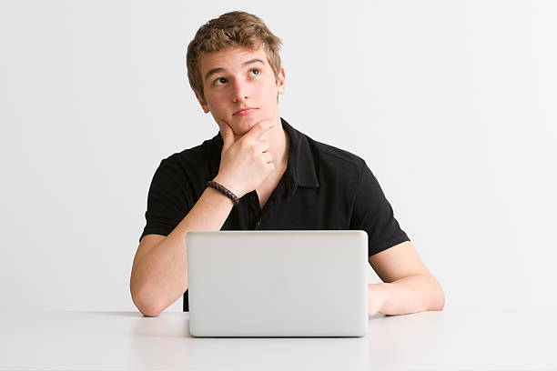 white guy thinking in front of his laptop