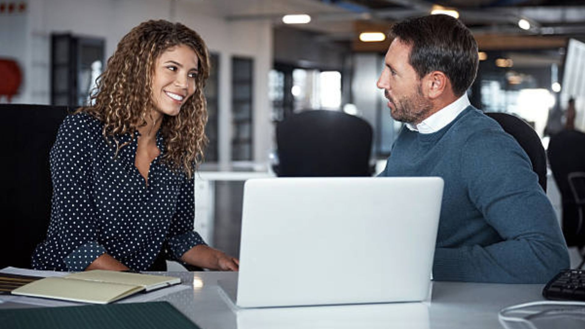 two colleagues smiling at each other