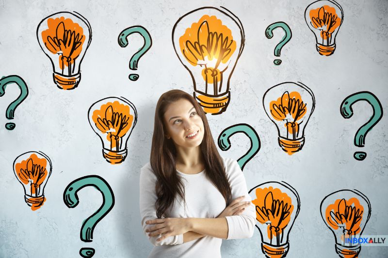 A woman stands with her arms crossed, smiling, surrounded by illustrated light bulbs and question marks on a white background, reflecting creative ideas about Bulk Email Practices for 2024.