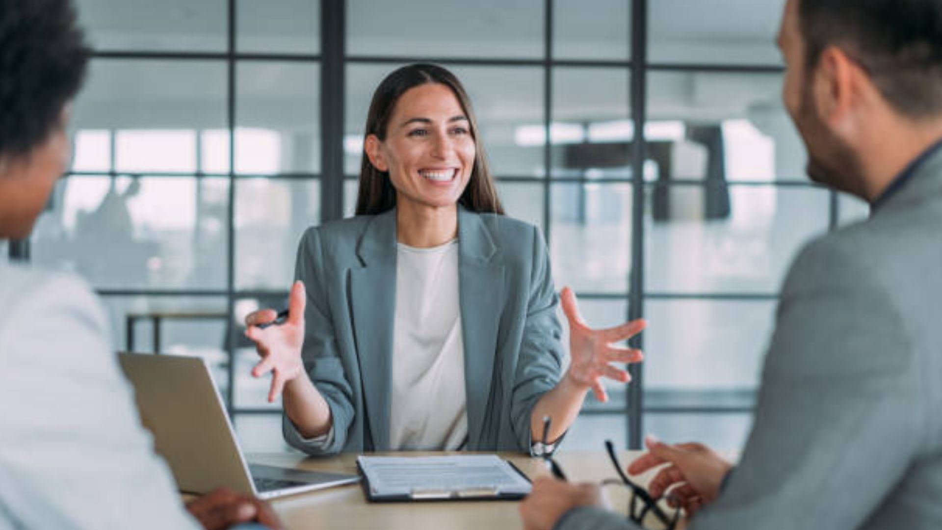 woman in a grey blazer explaining to other colleagues