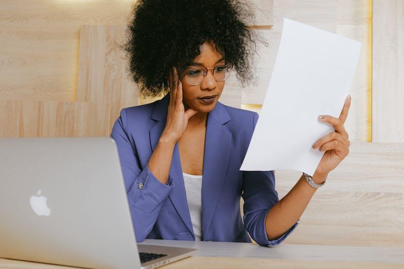 black woman in a purple blazer looking at a document - email deliverability