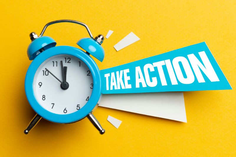 Blue alarm clock on yellow background with a take action sign.