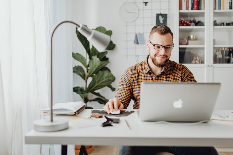 A man working on a laptop in his home office.