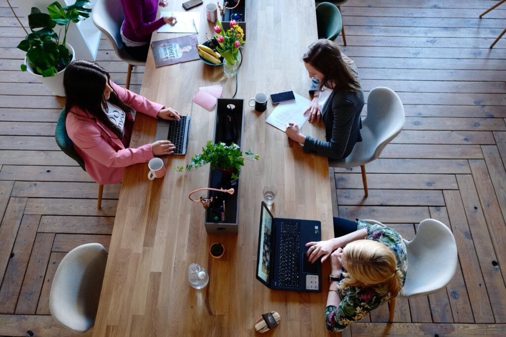 View from above a table with multiple people sitting and working.