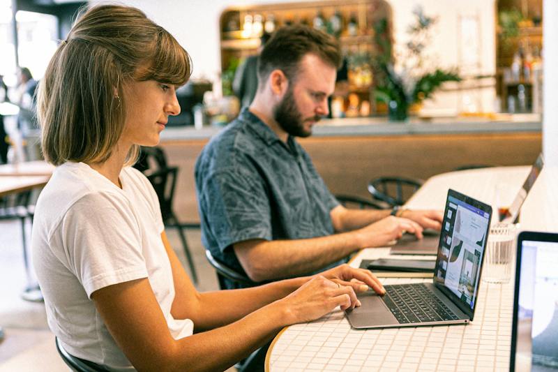 Woman working on a laptop designing an invitation.