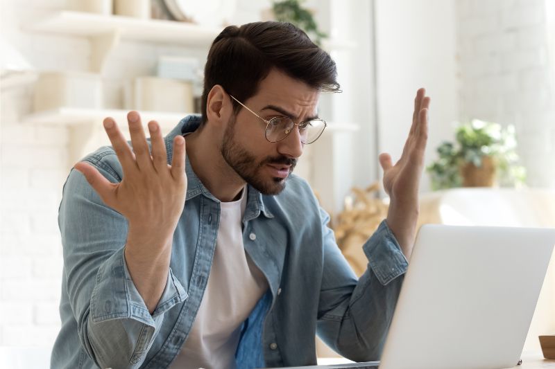 Frustrated man working on a laptop