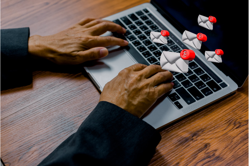 Mão digitando em um teclado de laptop, representando a conexão entre os ISPs e a capacidade de entrega de e-mail.