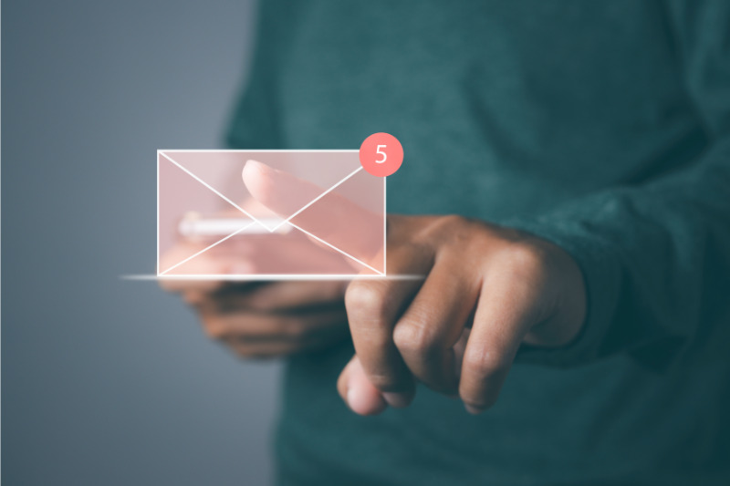 Man browsing through emails on a phone, with a notification indicating 5 new messages