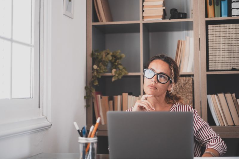 Uma pessoa pensando profundamente enquanto usa um laptop, considerando o problema de vários registros SPF para um domínio