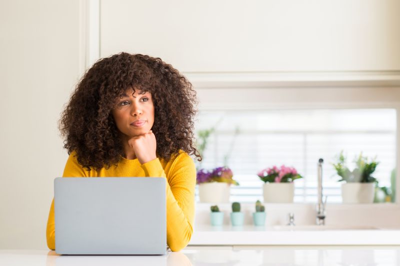 Mulher usando um laptop e encontrando problemas com a entrega de e-mails do Yahoo