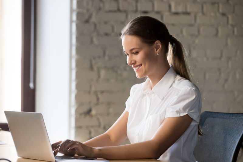 Uma mulher elaborando o e-mail frio perfeito que é aberto usando suas 21 dicas.