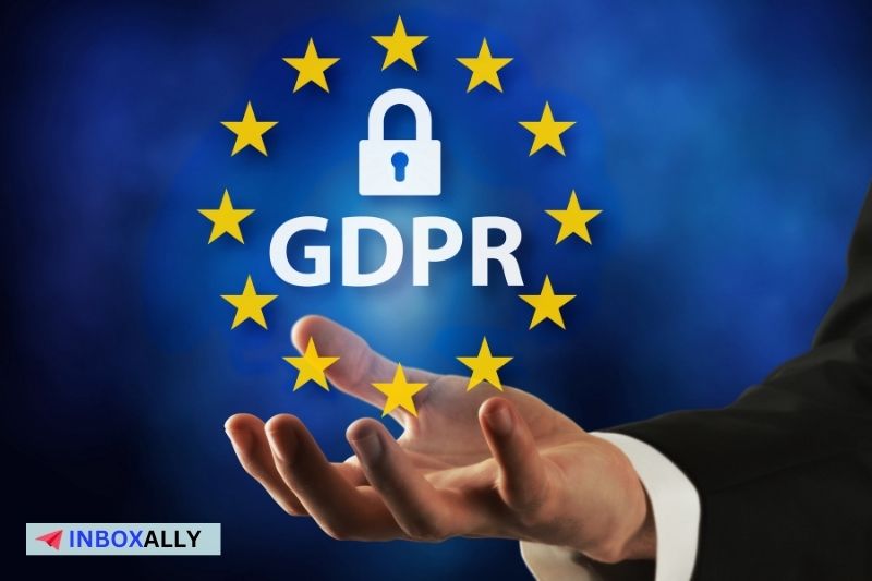 Mão segurando o símbolo do GDPR cercado por estrelas da UE, com um ícone de cadeado na parte superior, destacando as legalidades no envio de e-mails frios.