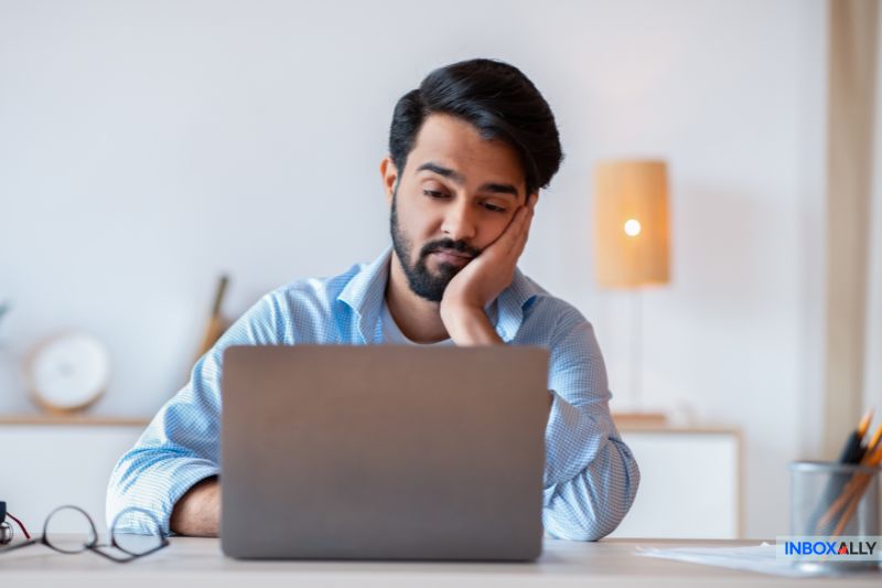 A man looks thoughtfully at a laptop screen, pondering the latest growth hack in his home office setting.