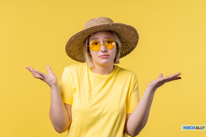Uma pessoa com chapéu de palha e óculos de sol amarelos encolhendo os ombros em um fundo amarelo vibrante, incorporando o estilo descontraído do verão enquanto pondera sobre as métricas.