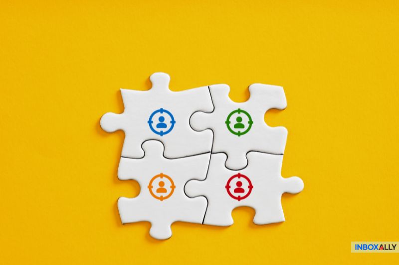 Quatro peças de quebra-cabeça brancas interligadas em um fundo amarelo apresentam, cada uma, um ícone de engrenagem e de pessoa em azul, laranja, verde e vermelho, simbolizando a sinergia de métricas como a taxa de cliques.