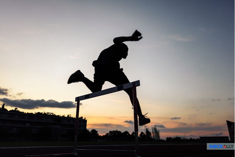 Silhouette of a runner overcoming hurdles, symbolizing challenges and milestones in the email marketing customer journey.