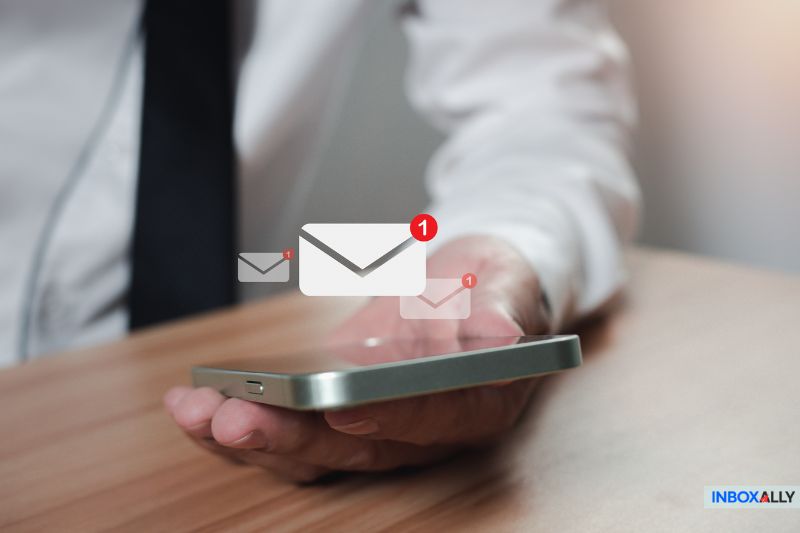 A person holds a smartphone with email notifications, each marked by red alert badges. Among these, one stands out: "550 5.1.1 error - User Unknown.