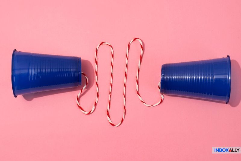Two blue cups connected by a twisted red-and-white string, symbolizing SMTP relay as a medium for email communication