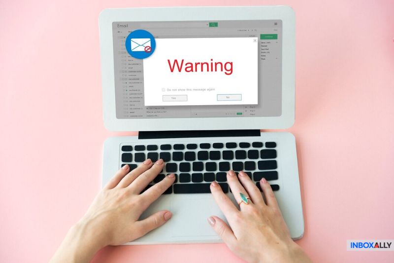 Hands on a laptop showing a 'Warning' message, symbolizing SMTP relay errors causing email delivery failures and blocked message