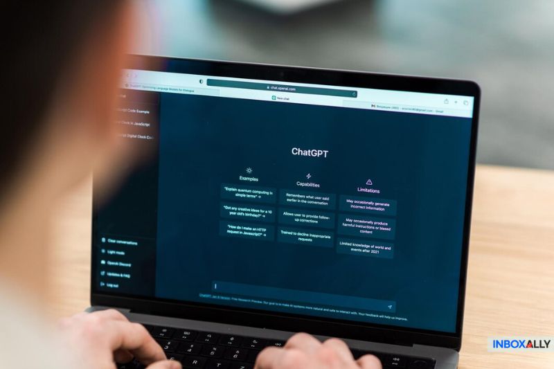 A person interacts with a laptop showing the ChatGPT interface, complete with examples and capabilities. The screen subtly introduces AI email personalization, offering a human feel while transparently outlining its limitations.