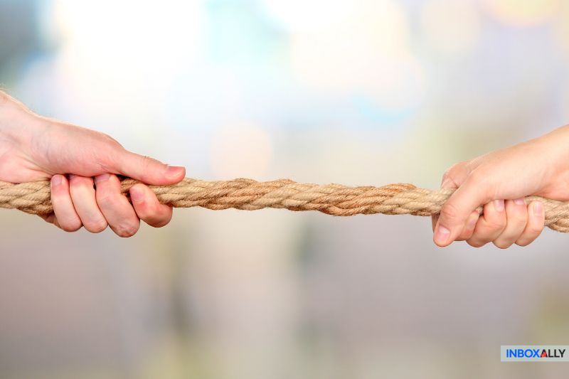 Two hands grasping opposite ends of a rope, suggesting a tug-of-war, embody the effort needed to manage complex tasks like an SEO strategy or setting up a hosted email spam filter.